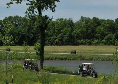 Golf carts are driven along the cart path by golfers at Falcon Lakes Golf Course.