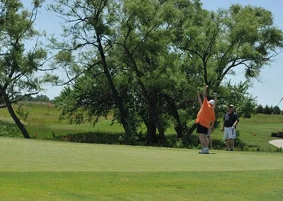 A group of golfers celebrate on the green at Falcon Lakes Golf Course.