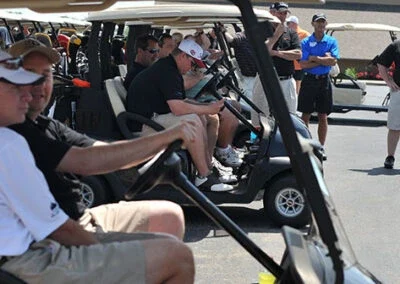 Golfers sit in golf carts, prepared for the start of an event at Falcon Lakes Golf Course.