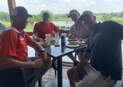 A group of golfers share a meal on the balcony of the Falcon Lakes Golf Course Clubhouse.