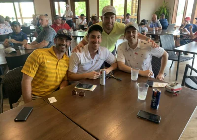 A group of golfers relax at a table in the Falcon Lakes Golf Course Clubhouse.