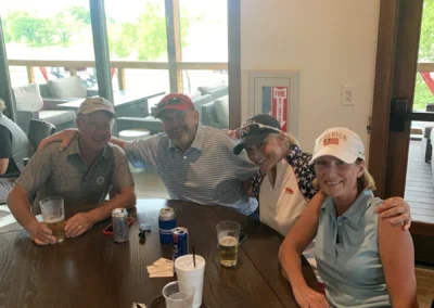 A group of golfers relax at a table in the Falcon Lakes Golf Course Clubhouse.